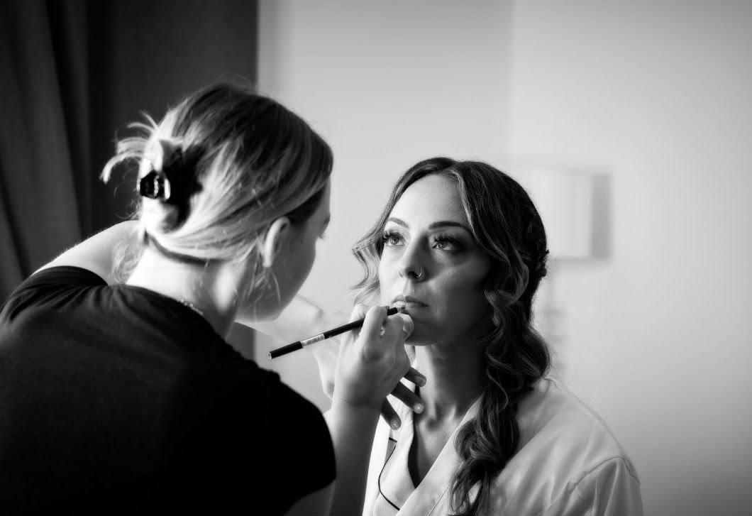 Charlie lining a bride's lips during wedding morning preparations